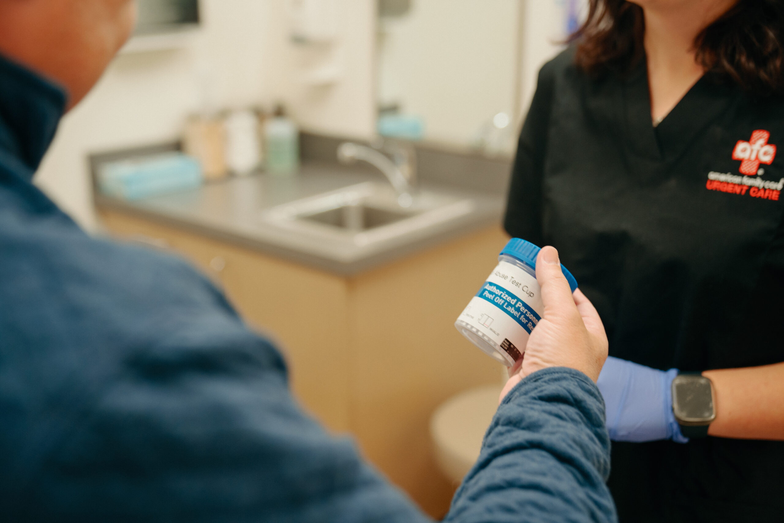 A patient holding a cup in the doctor's office.